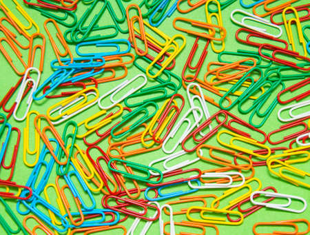 Colorful paper clip isolated on green background