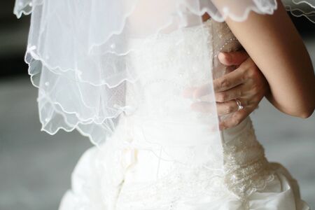 Bridesmaid holding bride's wedding dress