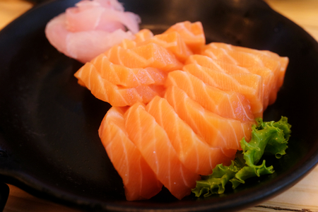 Sashimi salmon,fresh raw set in black plate on wooden tableの写真素材
