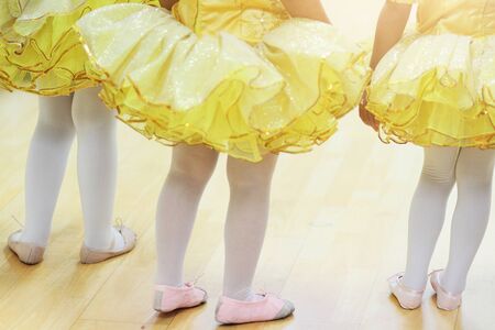 Little girls in yellow ballet tutu dress and pink ballet shoes.の写真素材