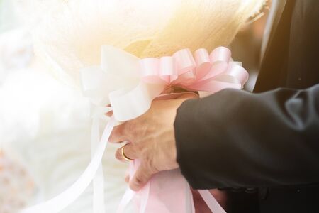 Groom holding rose flowers  bouquet with sunlight in marriage. Valentine Day for love and...