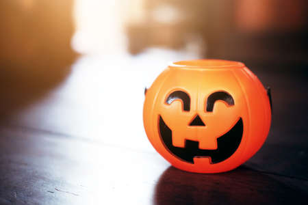 Smiling Halloween pumpkin head on wooden floor in natural shadow and sunlight. Halloween holiday concept.の写真素材