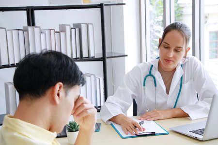 Professional Caucasian Female Psychiatrist (MD) is counseling and researching on website with laptop for treament asian man. Major depressive disorder patients and healthcare Concept.の写真素材