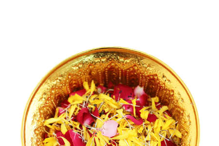 Red rose and Marigold flowers petals in gold tray isolated on white background in tradition Thai...