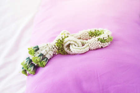Flower garlands on pink pillow in tradition Thai wedding ceremony day. Jasmine garland