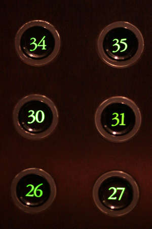 Buttons with green light numbers lift in the elevator.