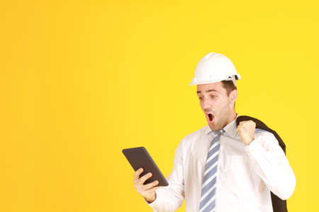 Handsome and smart engineer in suit and white shirt and Wearing a white safety engineering hat with...