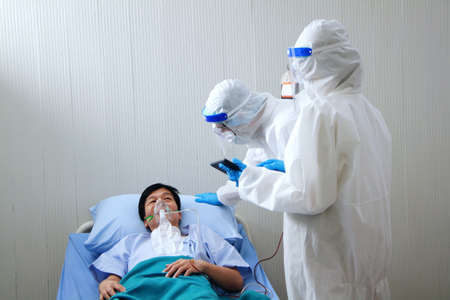 Medical team in Personal Protective Equipment or PPE clothing and use a respirator for asian old man...