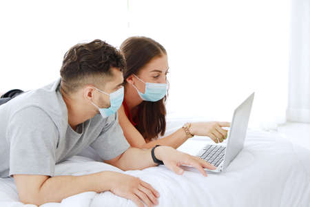 Caucasian Couple love wearing mask preventing for Covid 19 virus and shopping online in social media...