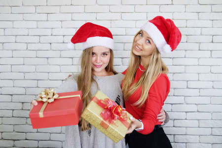 Smiling Caucasian couple sister is à¹holding big Gift boxes in Christmas party together. Lifstyle of Teenage lesbian on holiday concept.の写真素材