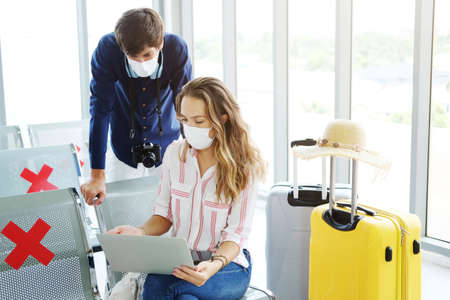 Young Caucasian traveler couple love wear mask for prevention for covid-19 virus is relaxing with...