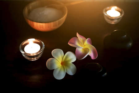 Pink and white Plumeria flowers with rock and Salt for exfoliation in wood Coconut cup on weave...
