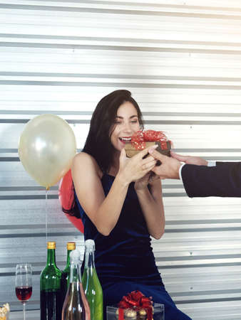 Sweet couple Love happy with surprise gift box girlfriend in christmas time and celebrating new year eve, Valentine day decoration with Christmas tree, colorful balloon and Gift Boxes in pantry Areaの写真素材