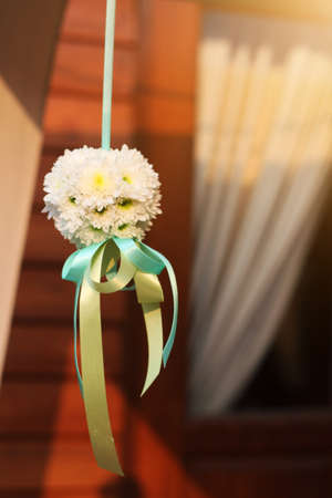White bouquet flowers with ribbon hanging decoration in wedding ceremonyの写真素材