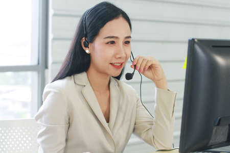 Businesswoman Call Center and technical Support staff with headset Smiling and talking in work....