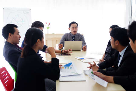 Senior Asian successful manager man is meeting and brainstorming with businesspeople staff and...
