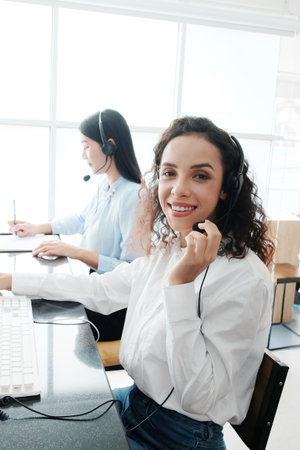 Smiling caucasian and asian women are call center or secretary operator is wearing a headset and a...