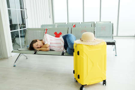 Caucasian traveler woman is sleeping on passenger While waiting to travel by plane in airport. à¹Jouney and travel for business trip with on vacation During the COVID-19 epidemic concept.の写真素材