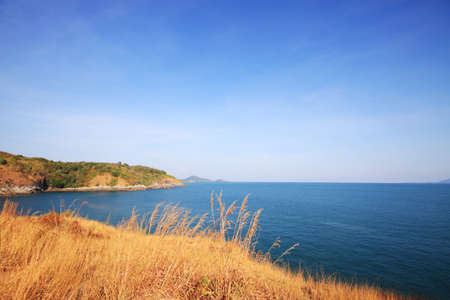 Beautiful seascape with sky twilight of sunset and sea horizon with Calm and blue sky.Dry grass field on mountain of Phrom Thep Cape is famous place in Phuket island, Thailand.の写真素材