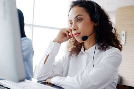Smling Caucasian woman call center or secretary operator with headset and microphone is thinking and consultant to customers. Technician Support staff for advise and help resolve technical issues.の写真素材