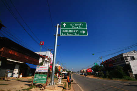 NAN, THAILAND-DECEMBER 13, 2015: Backpacker asian woman Hitchhike on the road at countryside in Thailandのeditorial素材