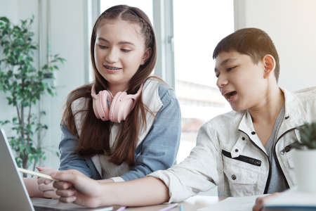 Smiling Caucasian students or pupils is learning online music with headphone. They are researching...