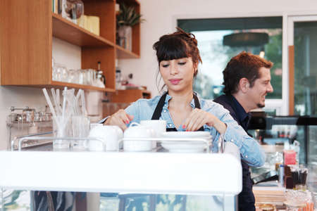 Smiling Caucasian Young barista couple love is wearing apron and working in the coffee shop. Start...