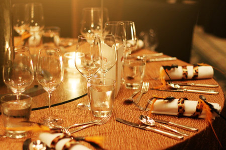 Bottle wine, wine glass , fork, spoon and greeting card decoration on wooden table with golden light...