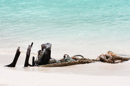Old Timber and rope on the beach and white sand with Blue sea in sunlightの写真素材