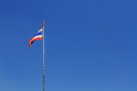 National Flag of Thailand is waving on pole with blue sky background
