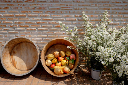 Blooming white flowers in vase and fruits in wood basket decorative for vintage brick wallの写真素材