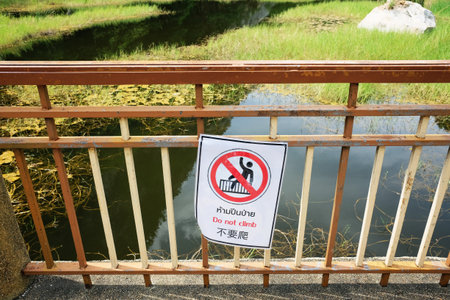 Rectangle caution do not climb Danger sign hanging on steel bridge for walkway. Warning sign for life guardの写真素材