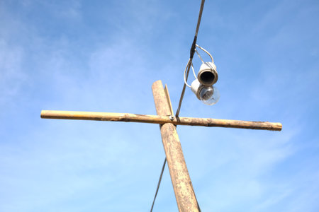Equipped and electrical with light bulbs is hanging with wooden pole in the wind and sunlight on blue skyの写真素材