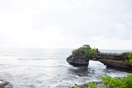 Ancient Tanah lot temple on coastal cliffs mountain and sea in Bali of Indonesiaの写真素材