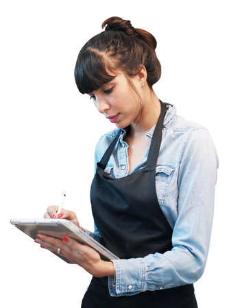 Smiling Caucasian Young barista woman is wearing apron and writing online order and menu on tablet...
