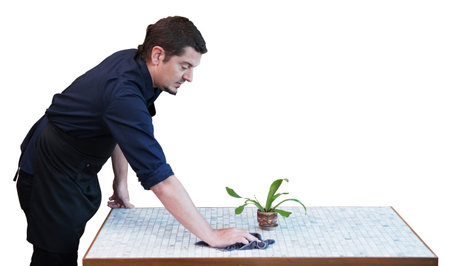 Professional handsome barista man wearing black apron and wiping the table in coffee shop isolated...