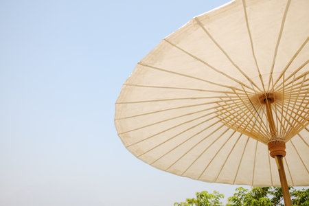 Handmade tradition white bamboo umbrella against bright blue sky in Chiangmai of Thailandの写真素材