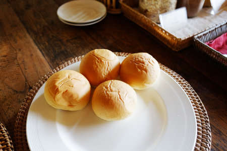 Fresh homemade bread rolls in white plate for breakfastの写真素材