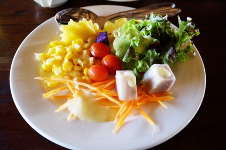 Fresh salad with sweetcorn and vegetable breakfast on wooden tableの写真素材
