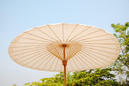Handmade tradition white bamboo umbrella against bright blue sky in Chiangmai of Thailandの写真素材