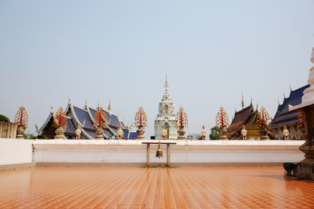 golden bell on orange ceramic tiles floor outdoor in Wat Den Sali Si Mueang Kaen temple in Chiang Mai Province in Thailandの写真素材