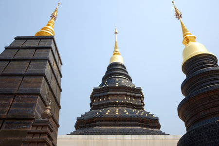 Ancient black with golden pagoda symbols of buddhism at Wat Den Sali Si Mueang Kaen temple in Chiang Mai Province in Thailandの写真素材