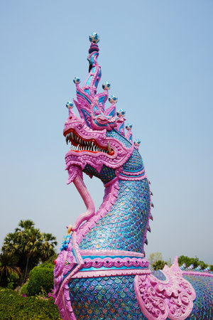 Pink and blue Naga statue and ancient stucco art in front of at Ancient pagoda of buddhism in Thailandの写真素材