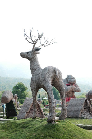 Chiangmai, Thailand - May 25, 2019: The deer puppet is made from woven straw into the shape of a large deer on green grass at Huay Tung Tao Reservoirの写真素材