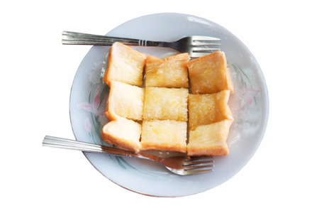 Homemade toast or bread with butter topping in white dish with forks isolated on white background with clipping pathの写真素材