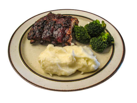 Tasty grilled ribs with vegetables and mashed potatoe isolated on whiteの写真素材