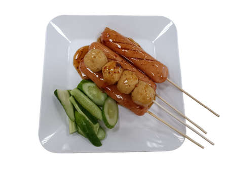 Fried sausage a grill on a stick in sauce, traditional food in Thailandの写真素材