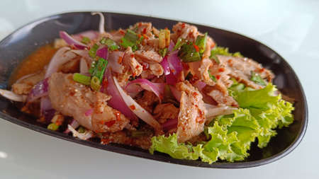 Thai food slide grilled pork salad or Nam Tok garnish with mint leaves and dried chili. Nam Tok is spicy Northeast foodの写真素材