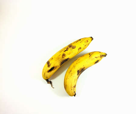 Spoiled yellow banana with spots isolated on a white backgroundの写真素材