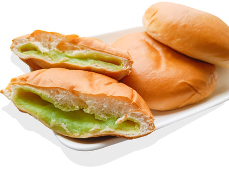 Side view. Pandan bun with custard filling on a white plate. isolated on white backgroundの写真素材